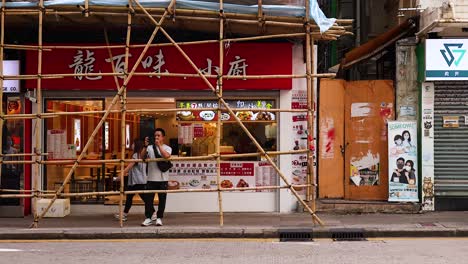 person standing outside a restaurant under scaffolding