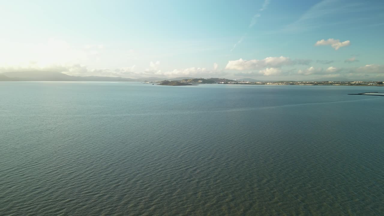 캘리포니아 주 버클리의 세자르 차베스 공원을 둘러싼 평온한 바다, 조용한 오후에 구름의 담요 아래의 부드러운 파도와 먼 산을 특징으로합니다.