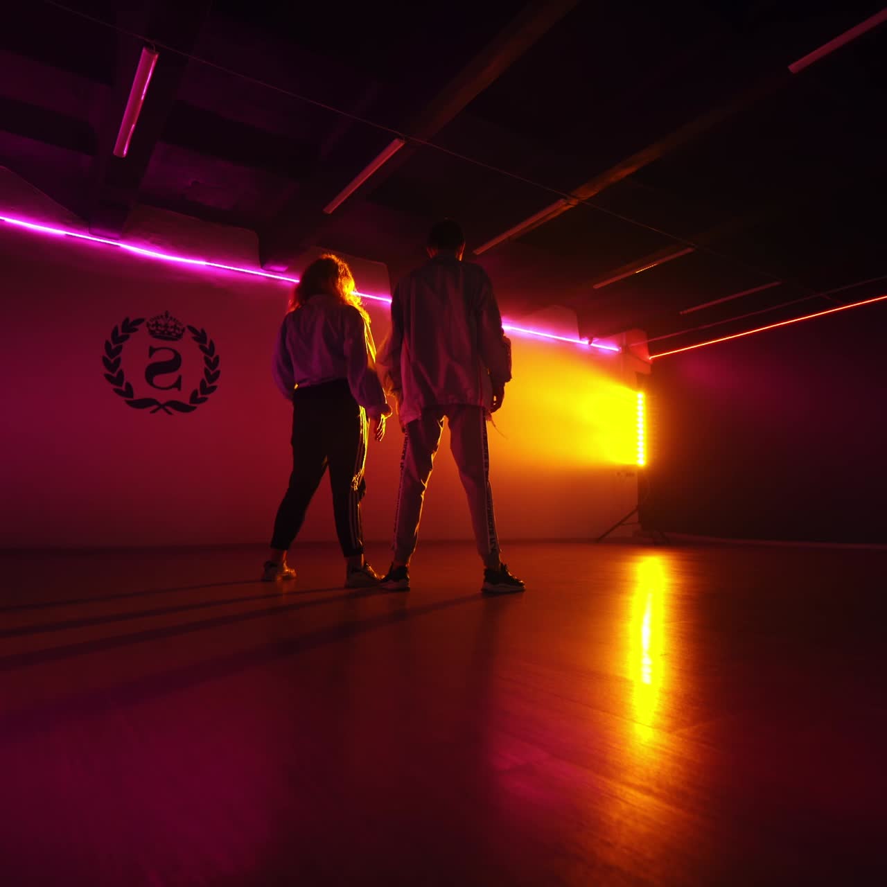 Modern dancing couple in studio. Talented dancers making perfomance in dark