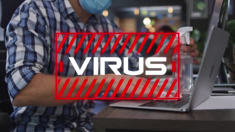 Virus-text-against-man-wearing-face-mask-cleaning-laptop-with-disinfectant-at-office