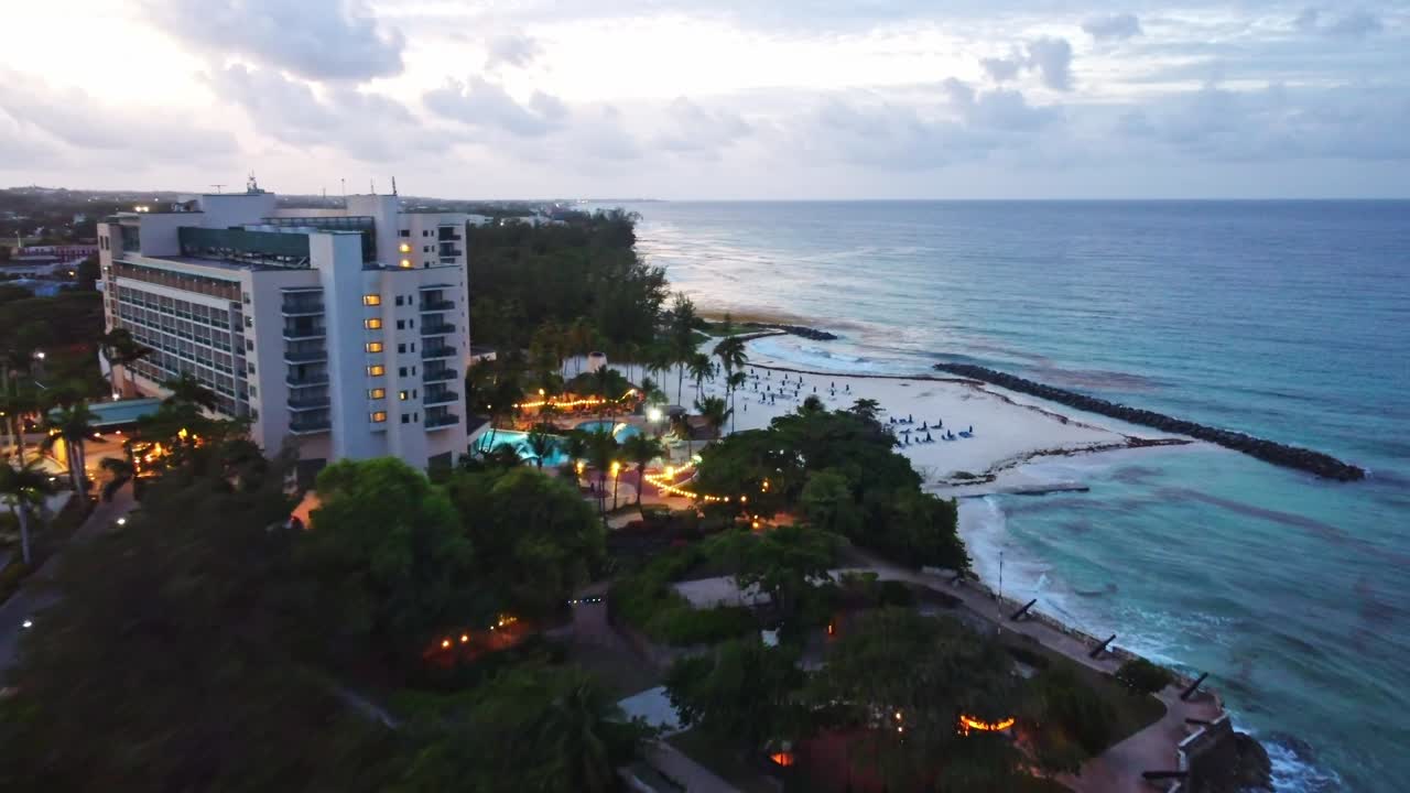 drone volando sobre un complejo de barbados al atardecer