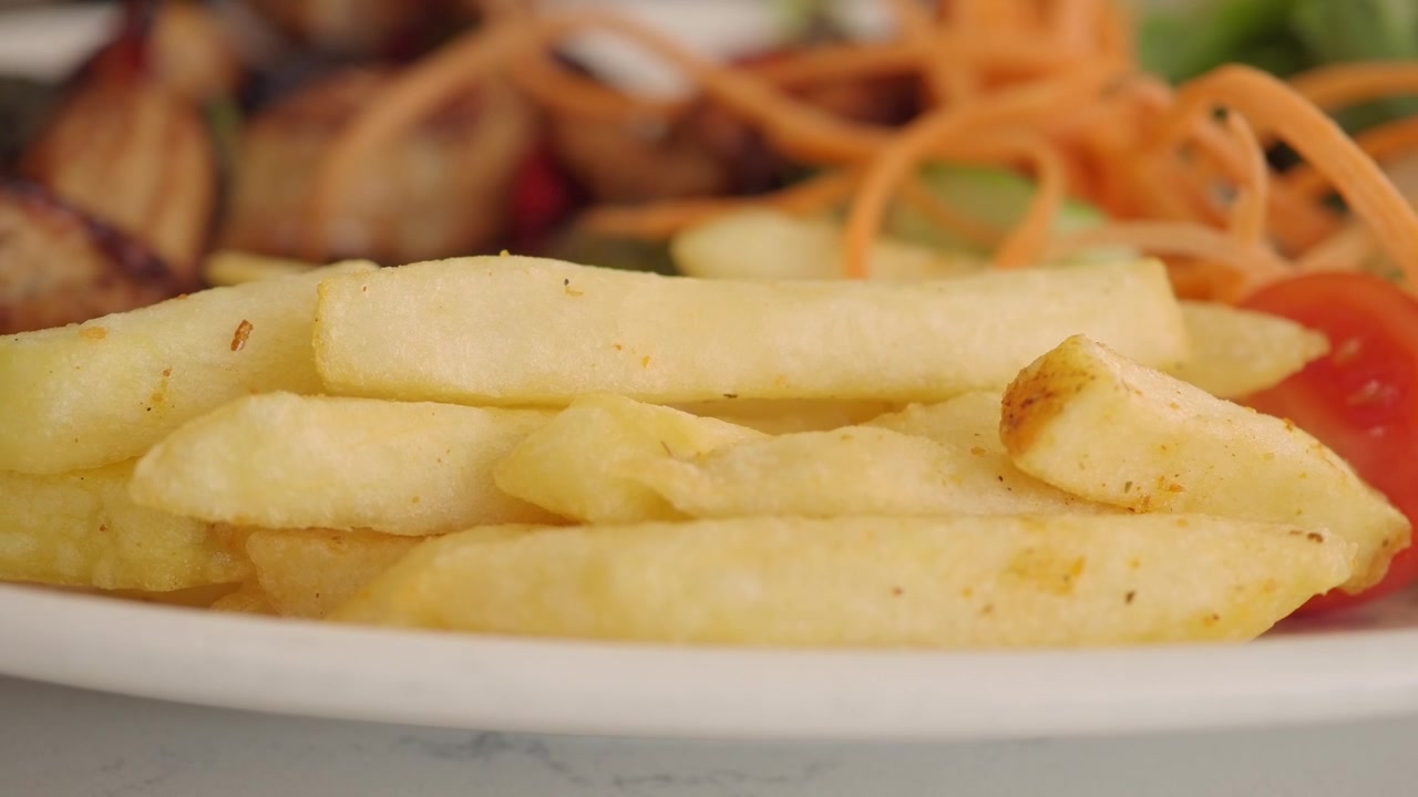 Close-up of a Person Eating French Fries with a Fork