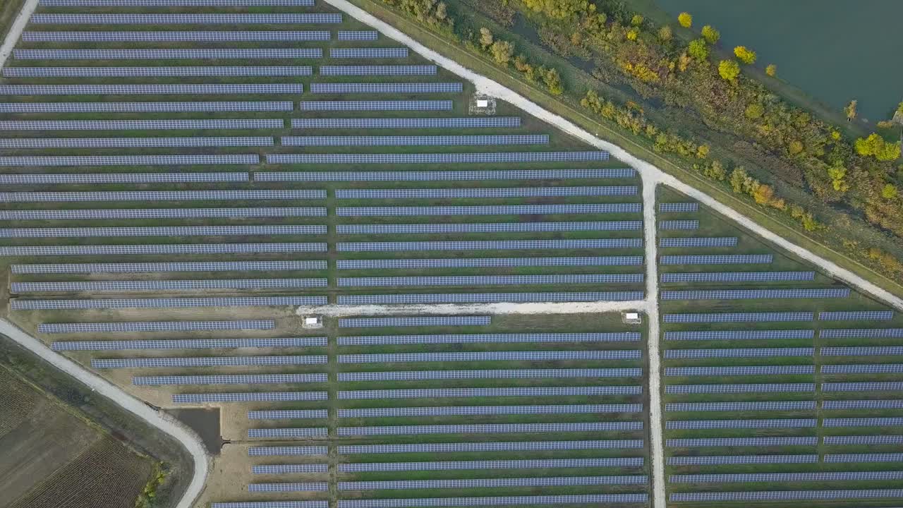 Top down aerial view of solar panels surrounded by agricultural land - wide shot