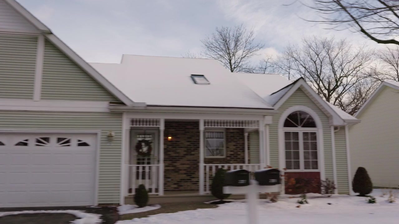 Passing Snow-Covered House with Double Garage and Arched Windows