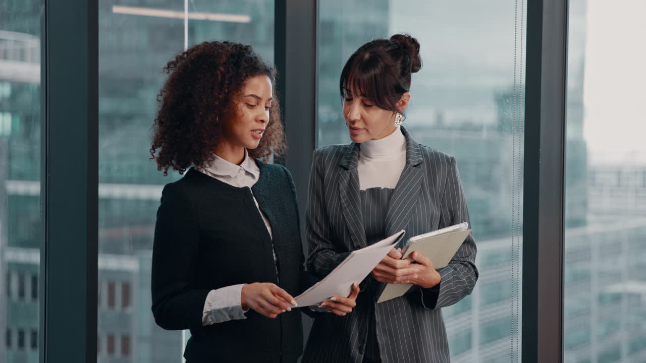 Businesswomen discuss documents in office