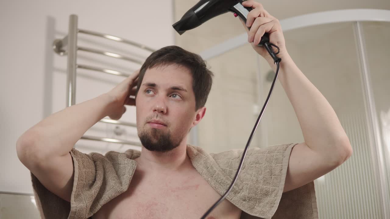 남자 가 화장실 에서 머리 를 건조 시키고 있다