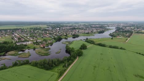 a river winding between green fields and a settlement-3