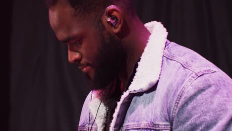 hombre afroamericano baila mientras toca un piano eléctrico durante un concierto