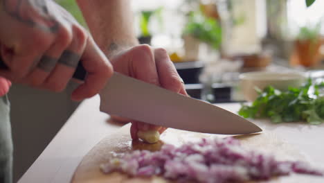 hands of chef slicing garlic
