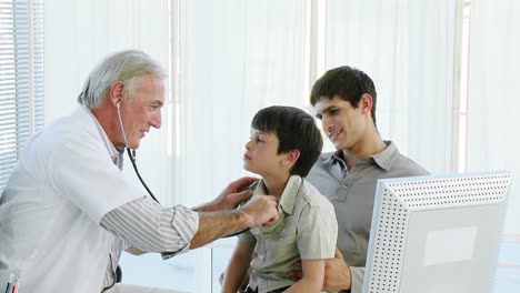 médico senior escuchando a un niño con un estetoscopio