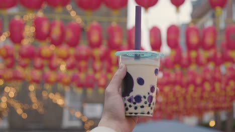 Nahaufnahme-Einer-Hand-Mit-Bubble-Tea-Zum-Mitnehmen-In-Chinatown,-London,-Großbritannien