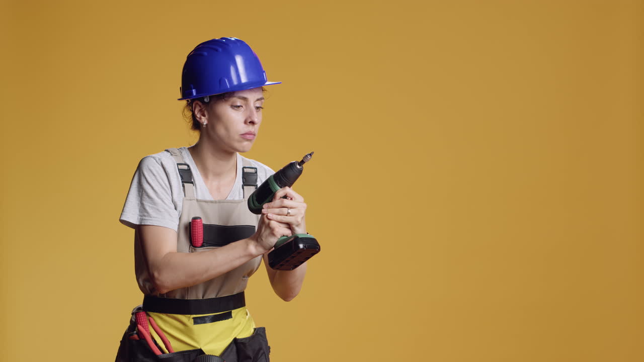 Female constructor working with power drill electric tool