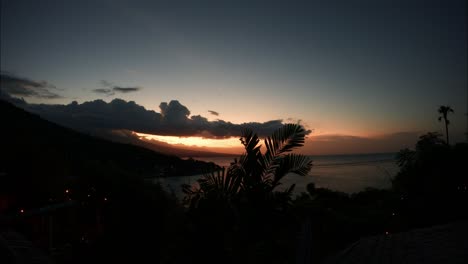 tropical sunset time lapse to darkness over ocean cliff as light fades away gently