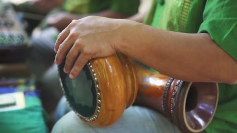 focused shot of man's arms as he plays the thai hand drums
