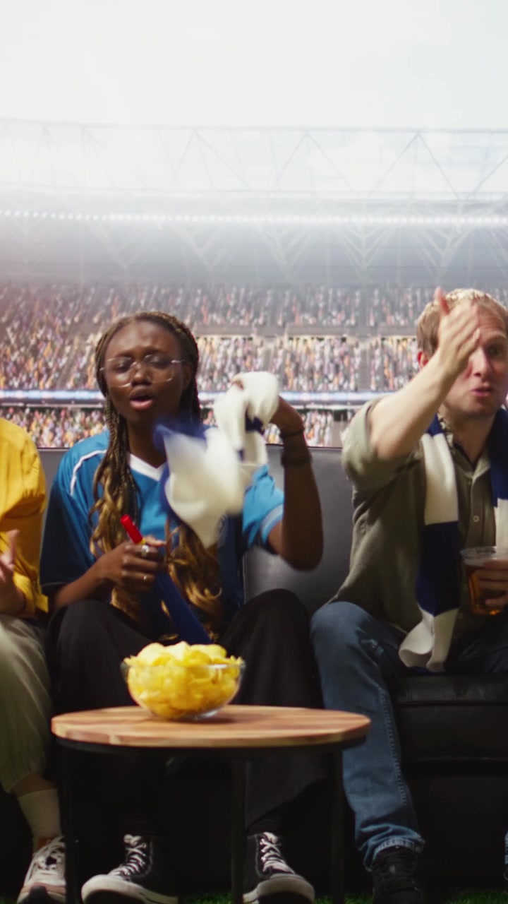 Video verticale. Tifosi di calcio con birra che guardano la partita trasmessa a casa, con un'esperienza da stadio.