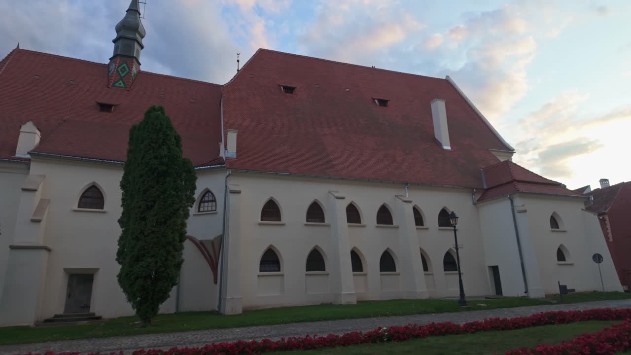 Side view of the Monastery's Church surrounded by a flowery promenade in the old town of Sighișoara, Romania