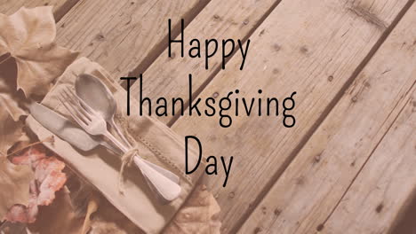 animation of happy thanksgiving day text over cutlery on wooden background