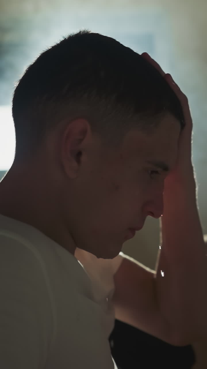 은 남자 권투 선수는 운동을위한 스포츠 클럽에서 손으로 습한 머리카락을 습니다. 격렬한 운동 후 긴장을 풀고, 운동 후 체력 향상 및 피로감을 느니다.