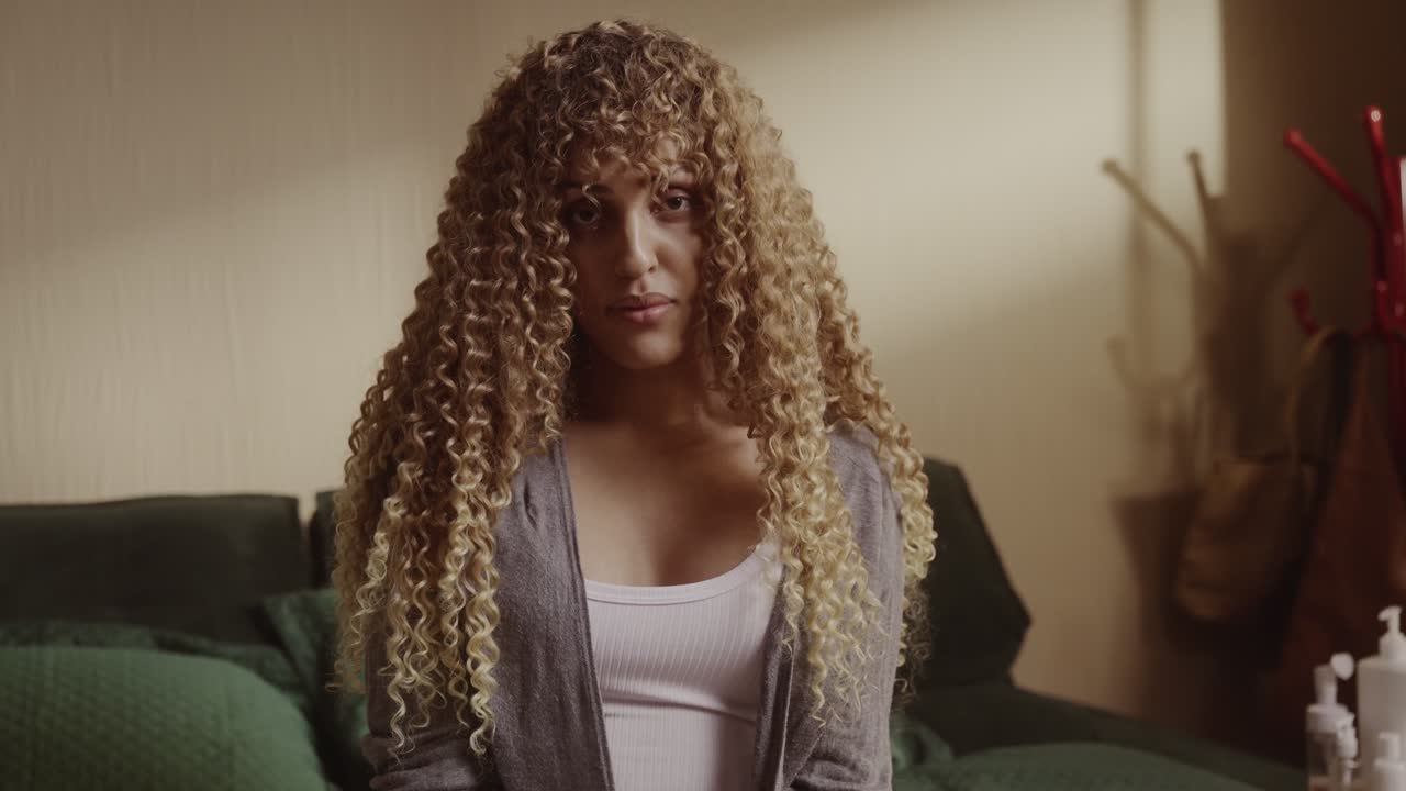 Portrait of a young woman with long curly blonde hair