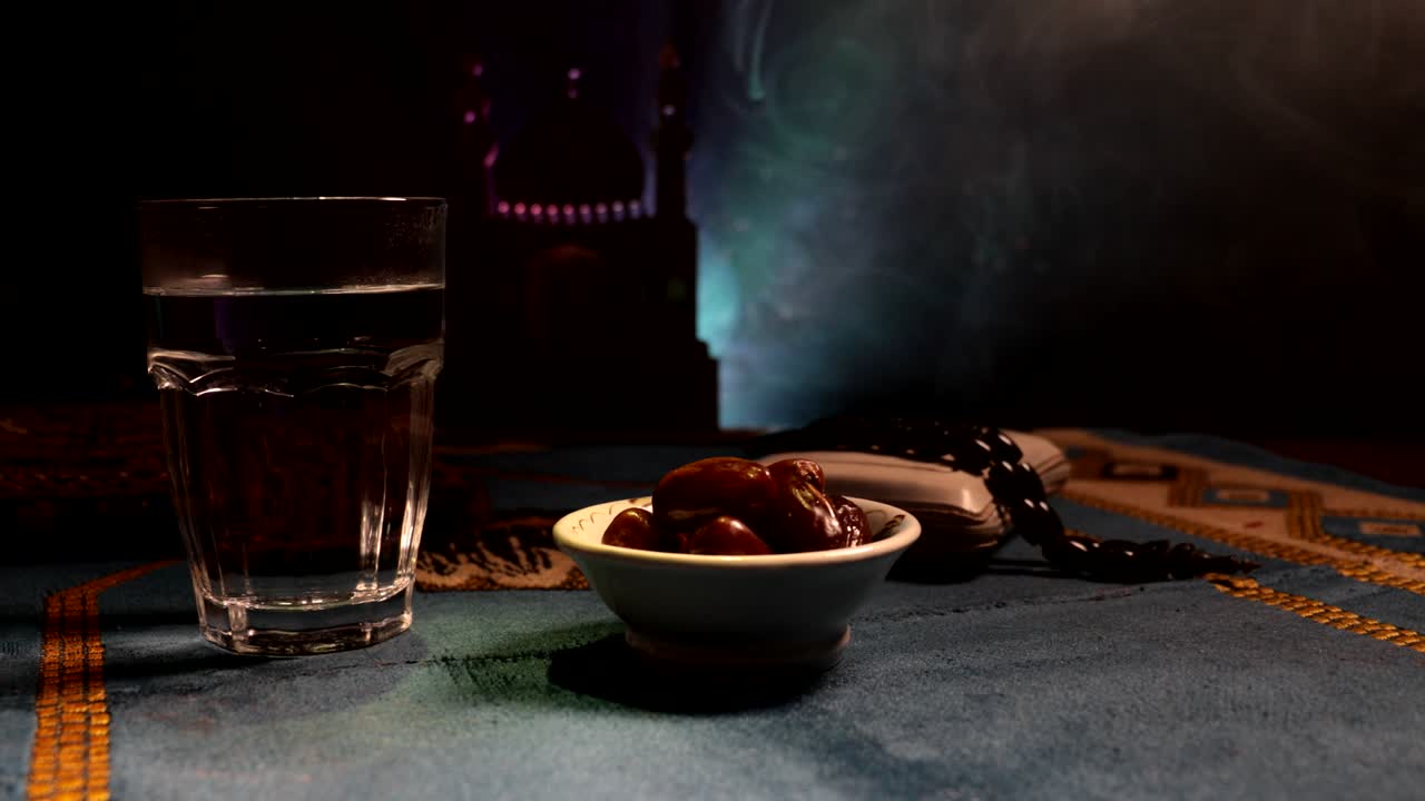 agua y dátiles. el iftar es la comida de la noche. vista deslizante de la decoración vacaciones de ramadán kareem. tarjeta de felicitación festiva, invitación para el mes sagrado musulmán ramadán kareem. fondo oscuro. enfoque selectivo