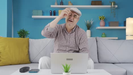 un anciano que usa una computadora portátil tiene dolor de cuello.