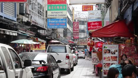 vehicles and pedestrians in a busy market street.