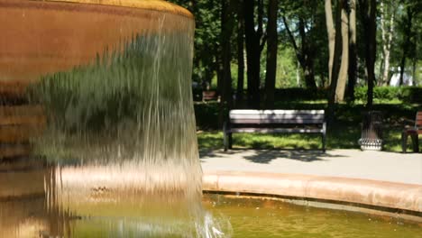 a small fountain with water in the summer park - a place of rest from the heat