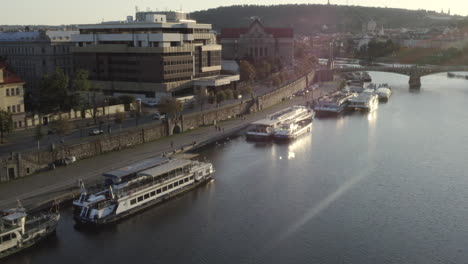 Boats-anchored-next-to-a-bridge,Vltava-riverbank-sunset,Prague,Czechia