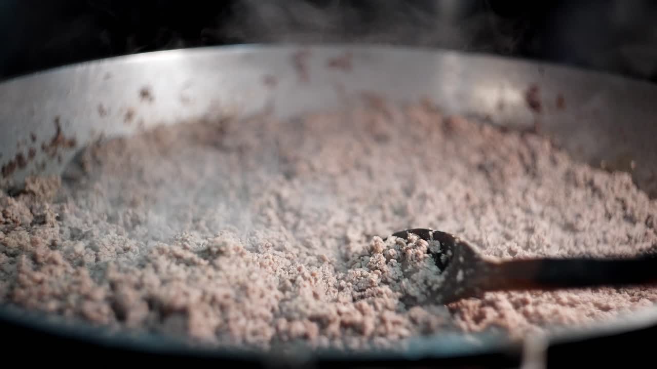 Close up view in slow motion of ground beef boiling in a pot ready to be cooked.