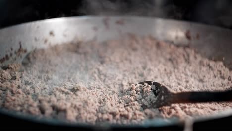 close up view in slow motion of ground beef boiling in a pot ready to be cooked.