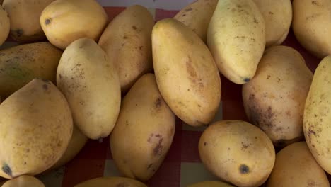 fresh thai mangoes overhead shot pan left to right close up at market stall in thailand