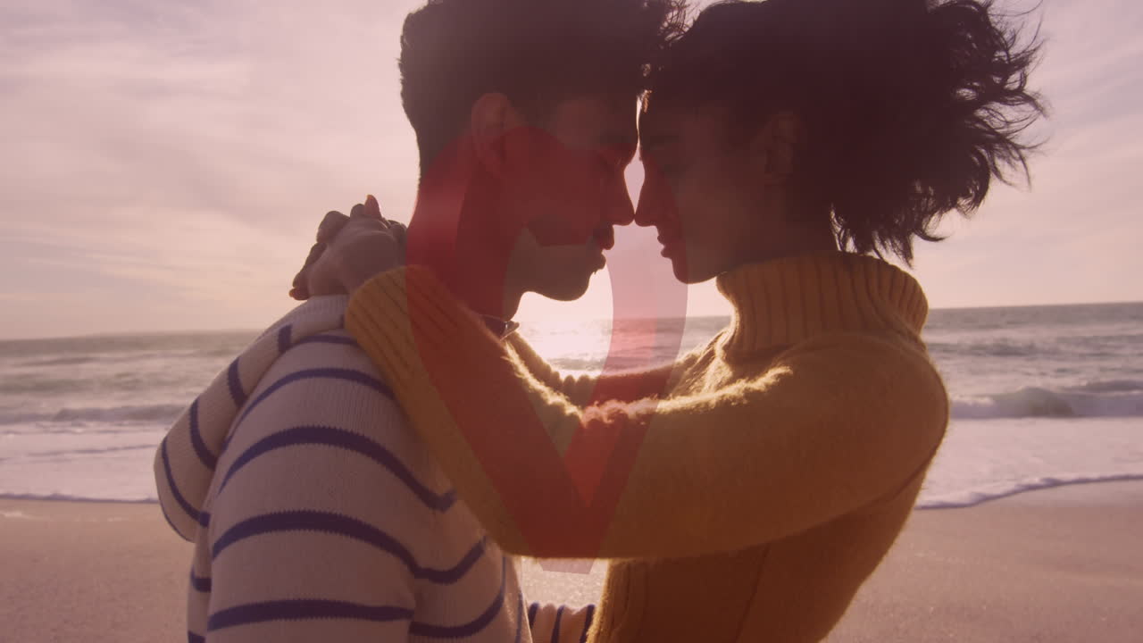 해변에서 포옹하는 사랑에 빠진 커플에 대한 빨간 심장의 애니메이션