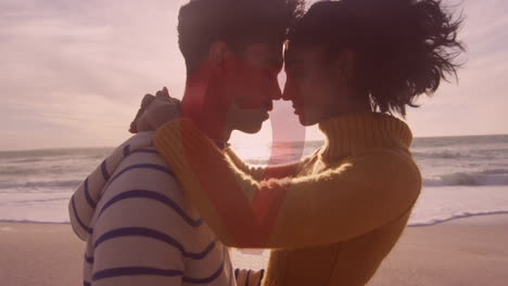 animation of red heart over couple in love embracing on beach