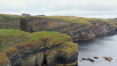 cinematic drone shot of whaligoe haven, the 250ft cliffs and rock walls overlooking the north sea in scotland