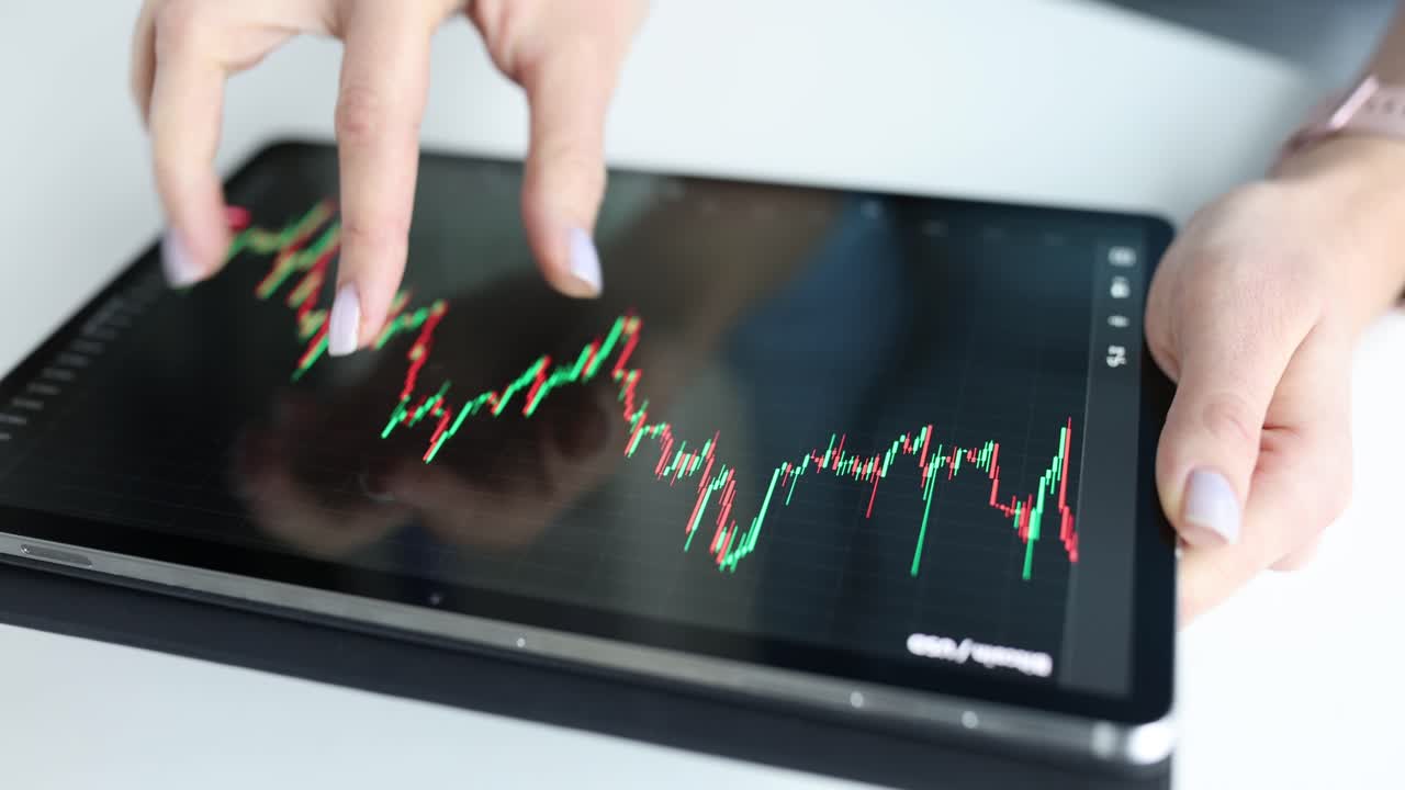 Mano femminile che esamina il grafico di crescita del tasso di criptovaluta sullo schermo di un tablet digitale, primo piano 4K