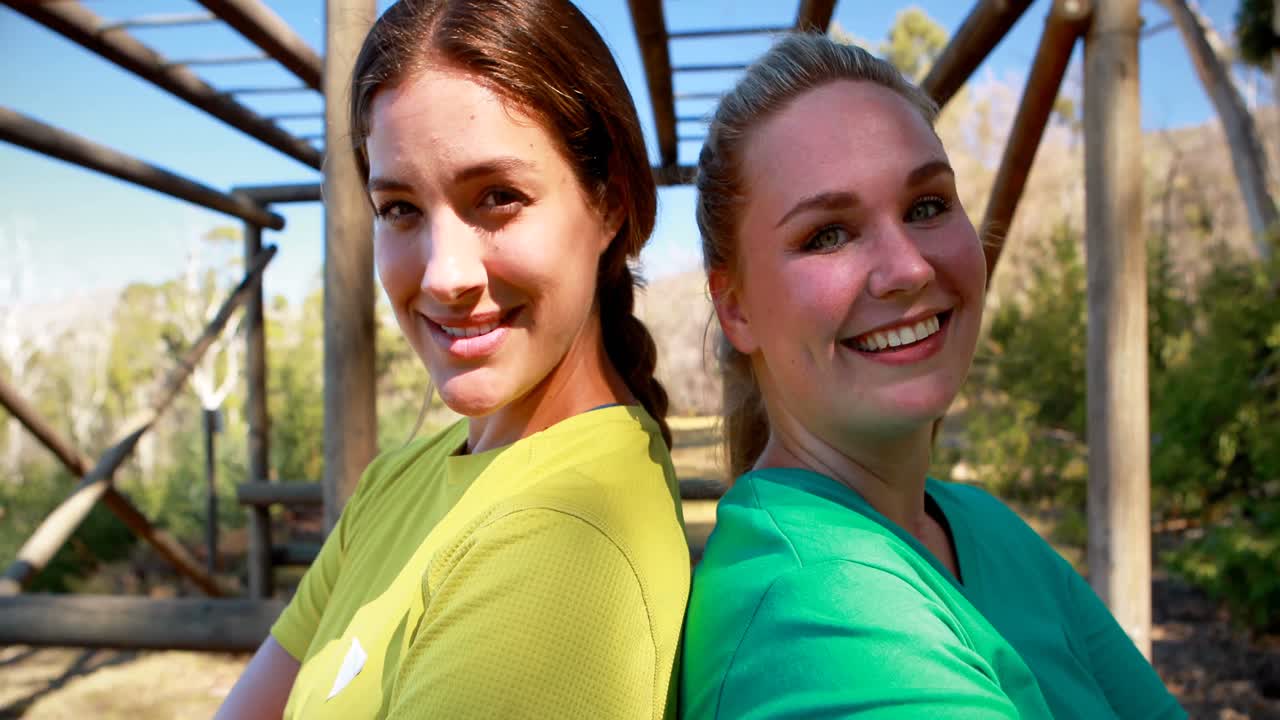 Portret van zelfverzekerde vrienden die rug aan rug staan tijdens een hindernisbaan