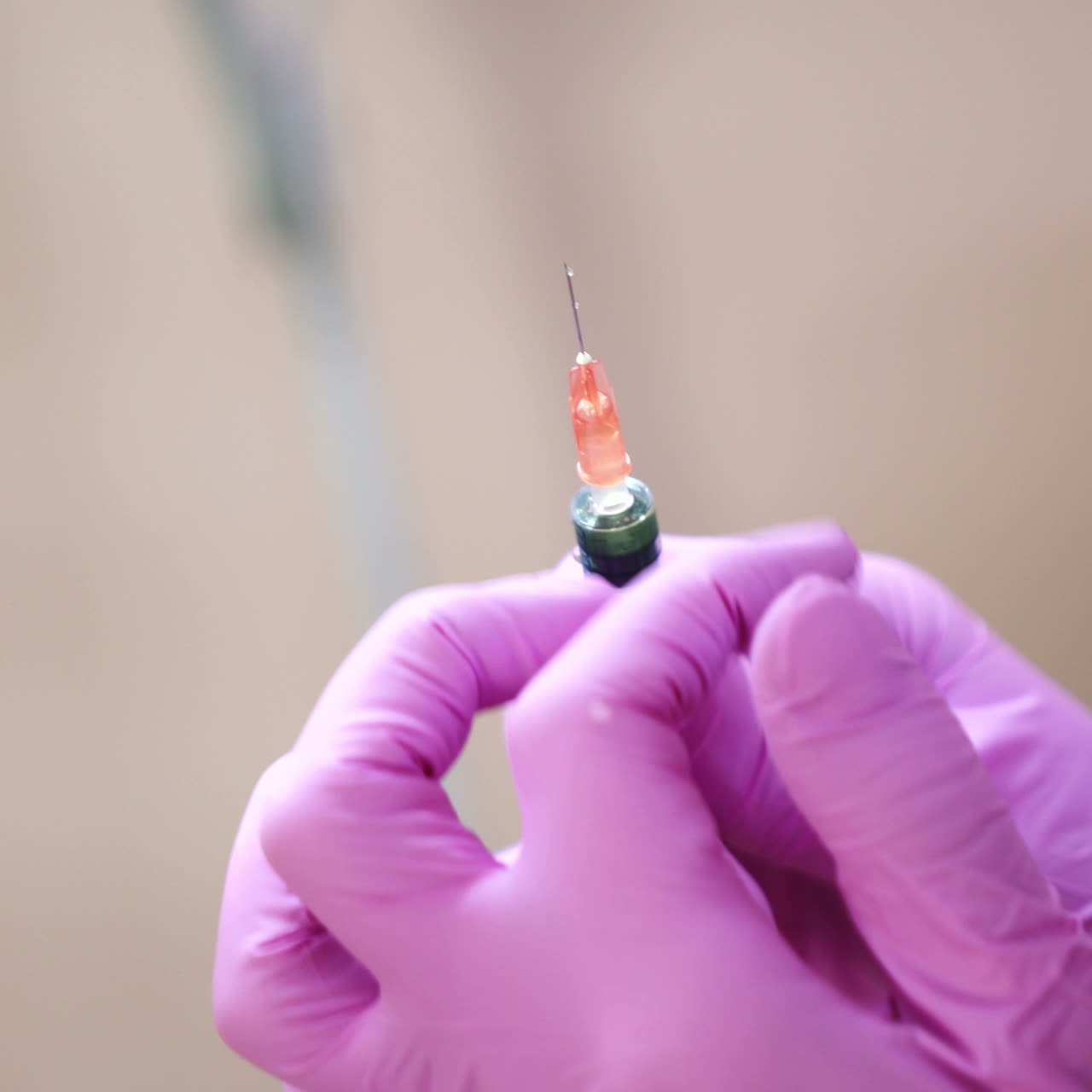 Close up of cosmetician s hand preparing a syringe for injection. Blur. Handheld real time close up shot