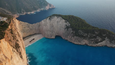 Imágenes-Cinematográficas-De-Drones-De-La-Icónica-Playa-De-Naufragios-De-La-Playa-De-Navagio,-Destacando-Los-Impresionantes-Acantilados-De-Zakynthos.