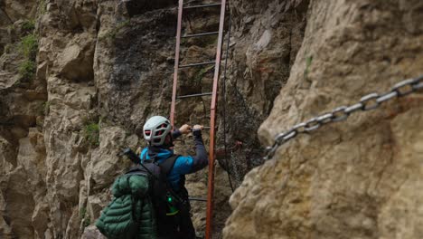 lombardy, italy - a mountain climber scaling grignetta with the help of a ladder - handheld shot
