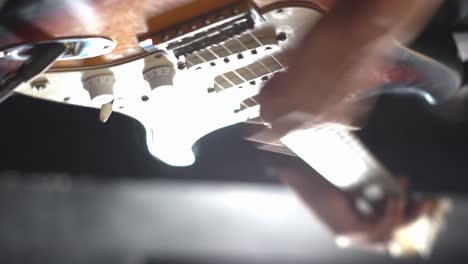 Person-hand-playing-boss-guitar-at-concert,-close-up-vertical-view