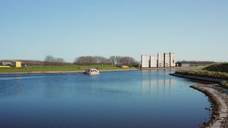 Aerial:-A-yacht-passing-the-locks-near-the-Canal-through-Walcheren,-near-the-historical-town-Veere