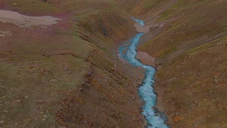 4K-Drohnenaufnahme-Mit-Vorwärtsflug-Entlang-Eines-Gletscherflusses,-Die-Eine-Schneebedeckte-Himalaya-Bergkette-Mit-Einem-Goldenen-Sonnenaufgangshimmel-Offenbart