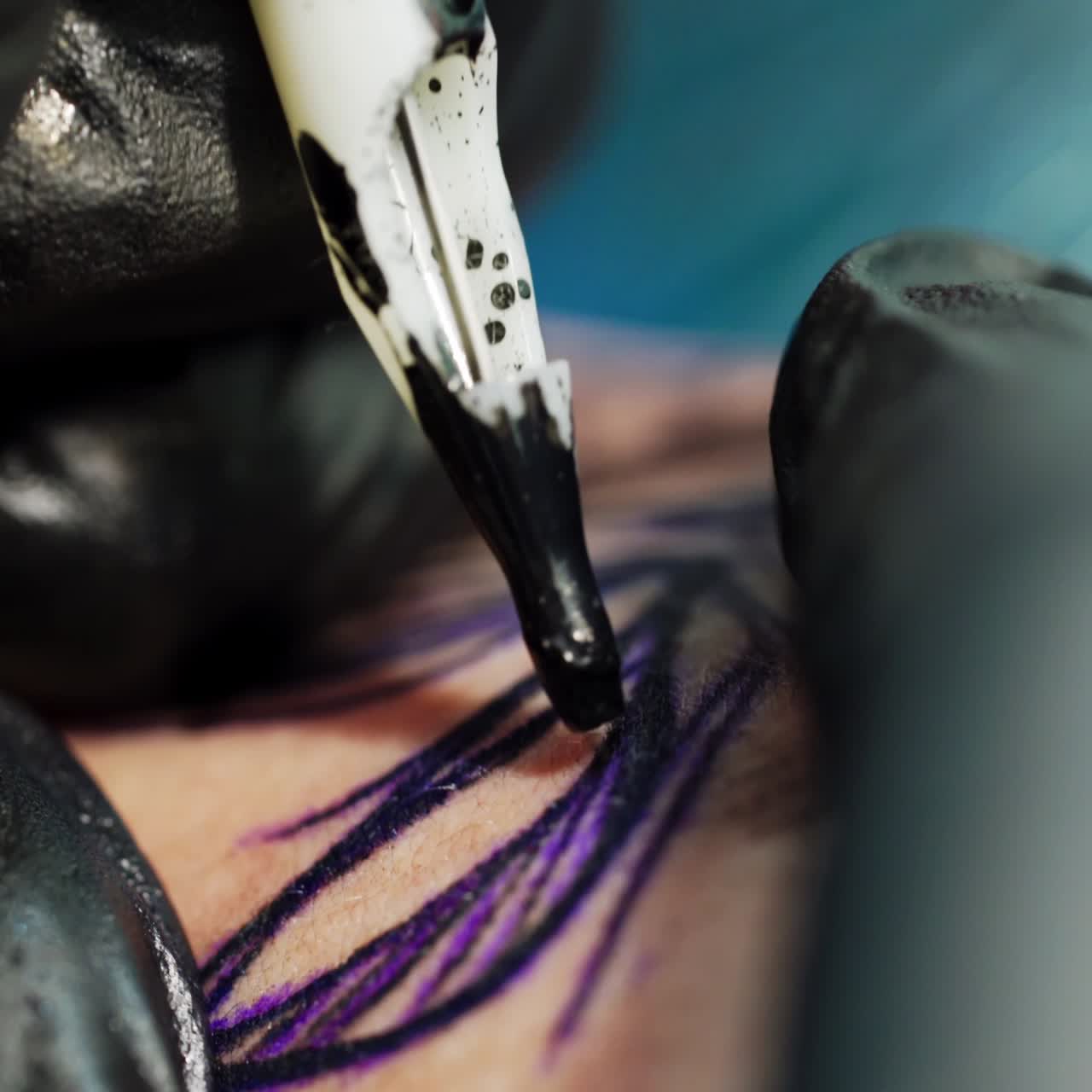 Macchinetta per tatuaggi che inietta l'inchiostro nello schizzo. Mani con guanti neri tengono e tendono la pelle. Primo piano