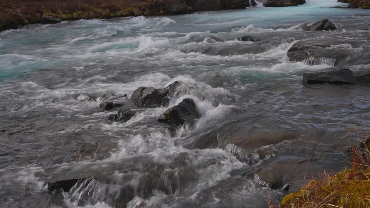 Flusso rapido del fiume che scorre impetuoso tra le pietre al fiume Bruara, Circolo d'Oro, Islanda sud-occidentale - inquadratura con inclinazione verso il basso