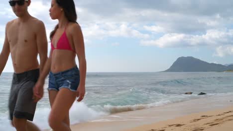 parejas caminando por la playa 4k