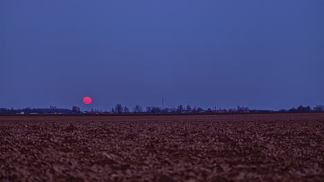 el lapso de tiempo de la luna es de un color carmesí brillante a medida que asciende hacia el cielo