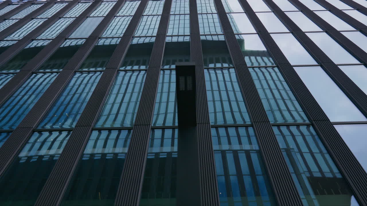 Vista abstracta del reflejo en la reluciente fachada de cristal de un edificio de oficinas