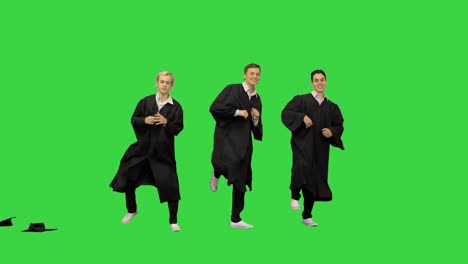 tres graduados varones felices lanzando cartones de mortero en el aire y comenzando a bailar en sincronía en una pantalla verde, clave de croma