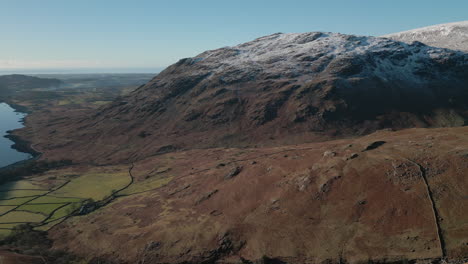 flying fast past hiker on mountainside with valley and mountains reveal at wasdale lake district uk