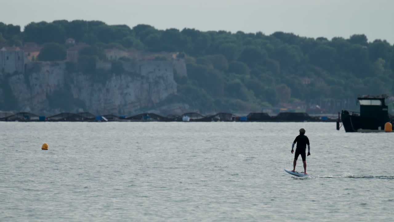 Cannes, France - October 8, 2025: A man balances on an electric foilboard gliding smoothly over the water near the coast